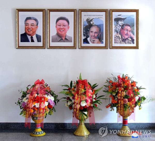 This file photo, carried by North Korea's official Korean Central News Agency on Aug. 15, 2023, shows the photos hung at the Cuban Embassy in Pyo<em></em>ngyang of North Korea's late founder Kim Il-sung (L), late leader Kim Jong-il (2nd from L) and late Cuban President Fidel Castro and his brother Raul Castro. (For Use o<em></em>nly in the Republic of Korea. No Redistribution) (Yonhap)