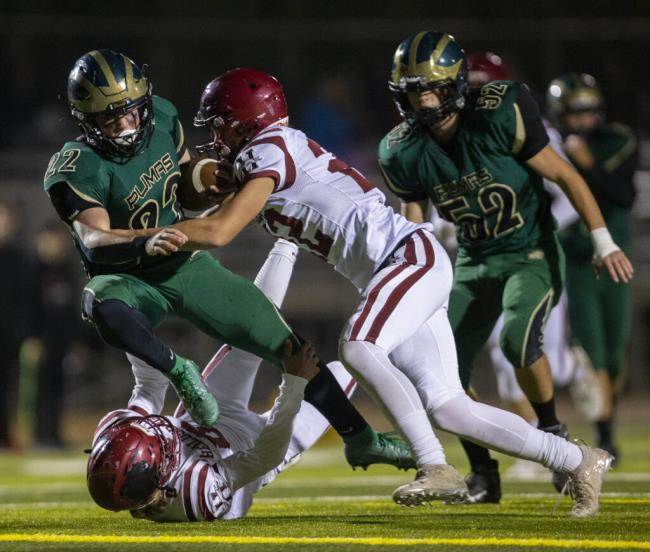 Maria Carrillo’s Logan Bruce is tripped up by Healdsburg’s Nova Perrill II as Nathaniel Rowland closes in during the fourth quarter of their game in Santa Rosa on Friday, Oct. 21, 2022. (Chad Surmick / The Press Democrat)