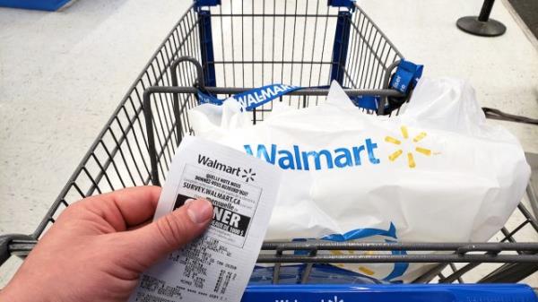 Walmart shopping cart with bag and receipt in Walmart store