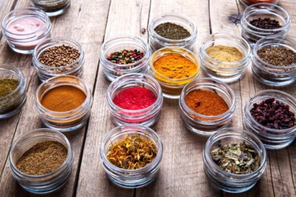 small glass bowls of spices on wooden table