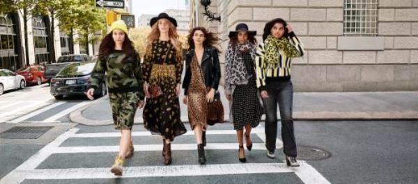 Four young women walking down a city street in fashio<em></em>nable clothes, marketing Walmart's Scoop clothing line.