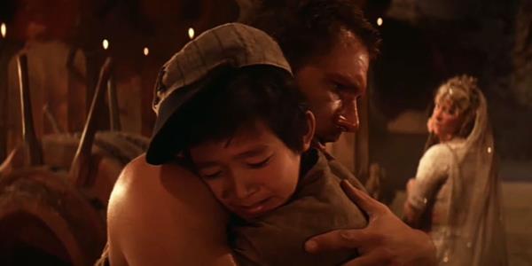  Ke Huy Quan as Short Round and Harrison Ford as Indy hug each other in Indiana Jo<em></em>nes and the Temple of Doom