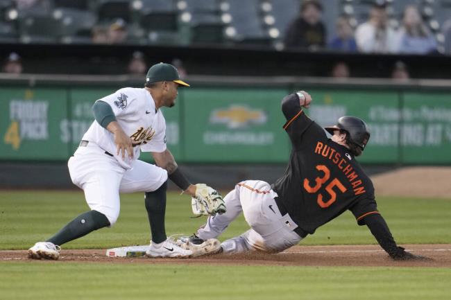 The Baltimore Orioles’ Adley Rutschman slides safely into third ba<em></em>se next to A’s third ba<em></em>seman Jordan Diaz during the fourth inning in Oakland, Friday, Aug. 18, 2023. (Jeff Chiu / ASSOCIATED PRESS)