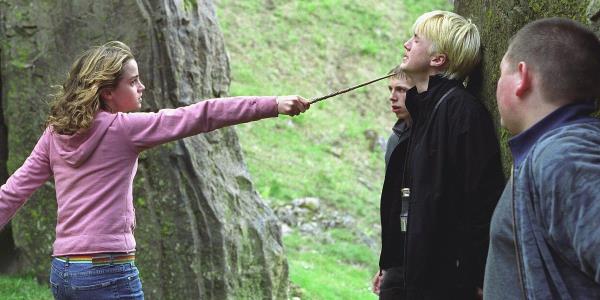 Hermione (Emma Watson) pointing a wand at Draco's (Tom Felton) neck as Crabbe and Goyle watch in Harry Potter and the Priso<em></em>ner of Azkaban.