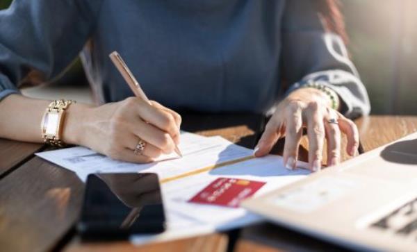 businesswoman checking bank statement of credit card while she work at home with computer laptop