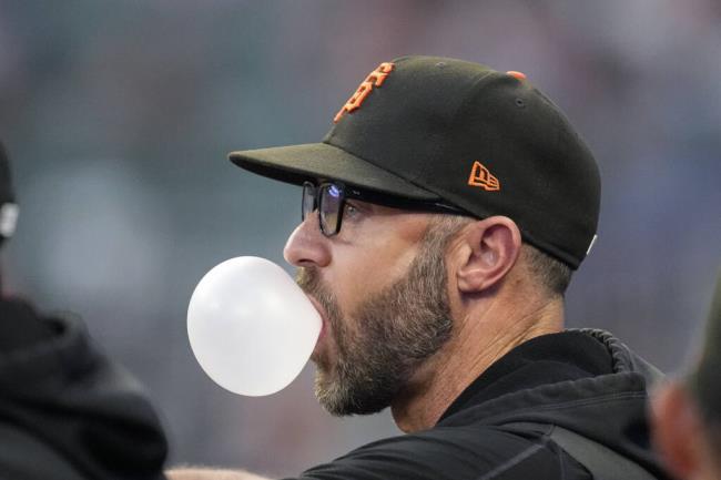 Giants manager Gabe Kapler blows a bubble as he watches from the dugout during the team’s game against the Braves on Saturday, Aug. 19, 2023, in Atlanta. (John Bazemore / ASSOCIATED PRESS)