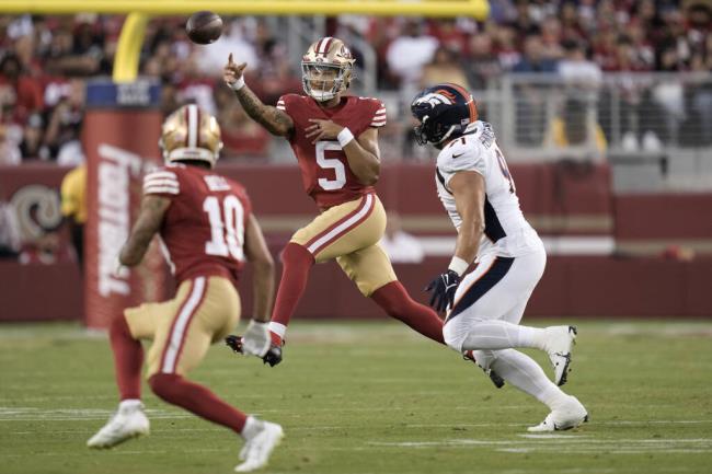 San Francisco 49ers quarterback Trey Lance passes the ball toward wide receiver Ro<em></em>nnie Bell (as Denver Bro<em></em>ncos defensive end Matt Henningsen applies pressure during the second half  in Santa Clara, Saturday, Aug. 19, 2023. (AP Photo/Godofredo A. Vásquez)