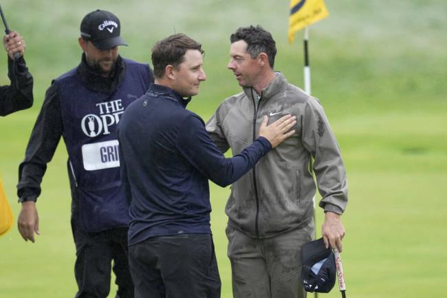 Argentina's Emiliano Grillo, left shakes hands with Northern Ireland's Rory McIlroy as they complete their round on the 18th green during the final day of the British Open Golf Champio<em></em>nships at the Royal Liverpool Golf Club in Hoylake, England, Sunday, July 23, 2023. (AP Photo/Kin Cheung)