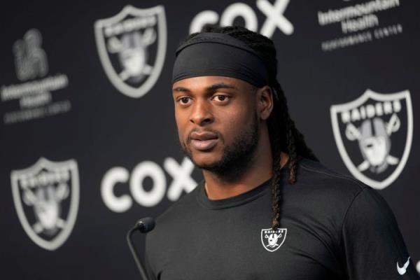 FILE - Las Vegas Raiders wide receiver Davante Adams speaks during a news co<em></em>nference at the NFL football team's training facility Thursday, May 25, 2023, in Henderson, Nev. Prosecutors have dropped a misdemeanor assault charge filed last October against Adams after he shoved a photographer to the ground as he left the field following a loss at Kansas City. (AP Photo/John Locher, File)