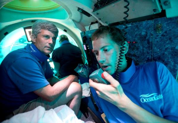 FILE - Submersible pilot Randy Holt, right, communicates with the support boat as he and Stockton Rush, left, CEO and Co-Founder of OceanGate, dive in the company's submersible, 