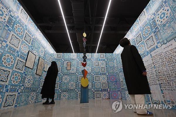 Visitors look at artworks on display during an exhibition in Seoul in this undated file photo. (PHOTO NOT FOR SALE) (Yonhap)